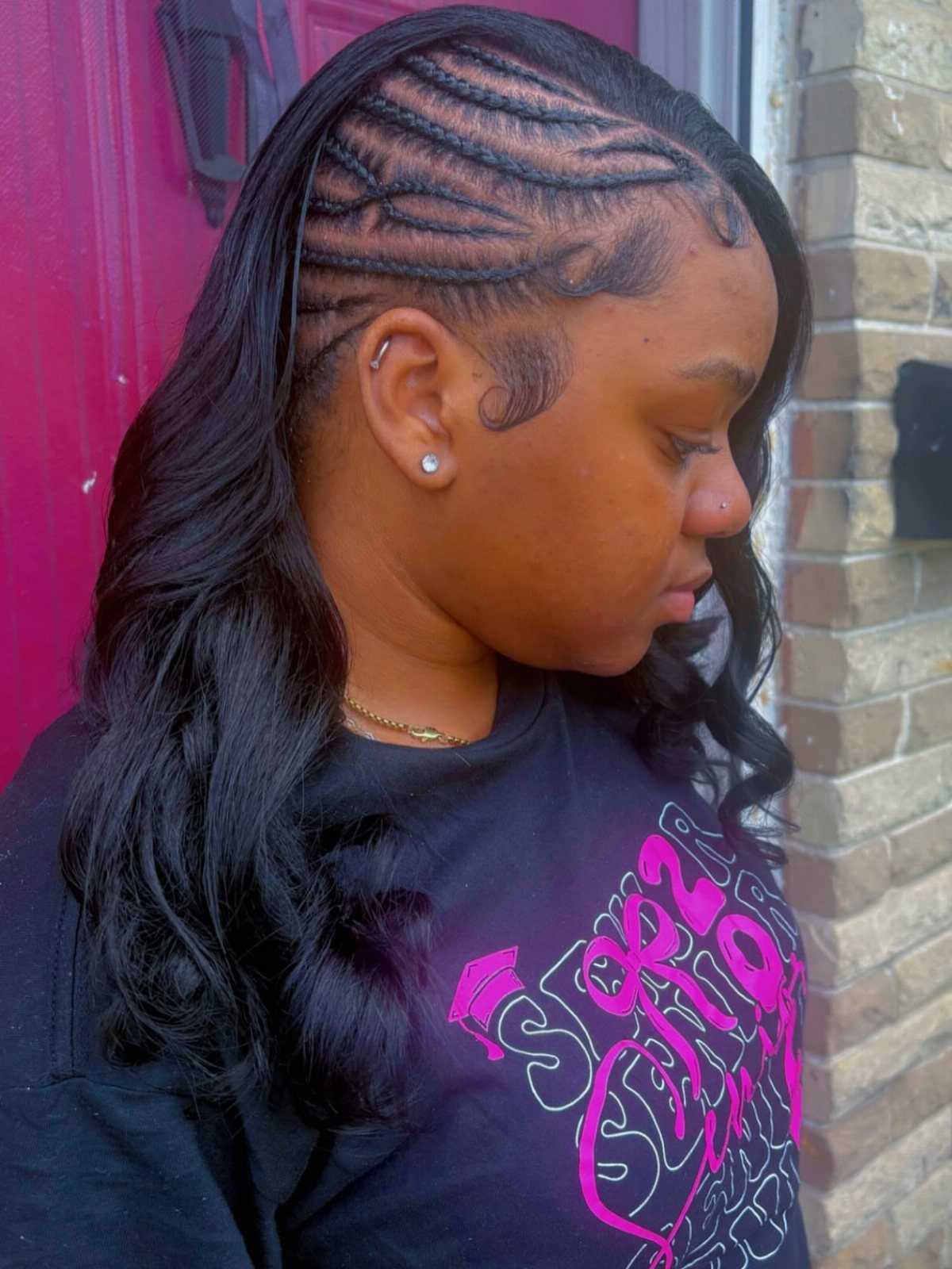 Person with intricate cornrow braids to the scalp and long wavy black hair.