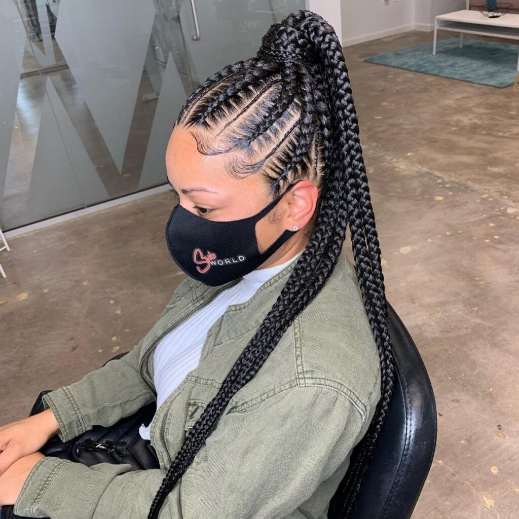 Woman with thick goddess braids styled into a high, long ponytail.