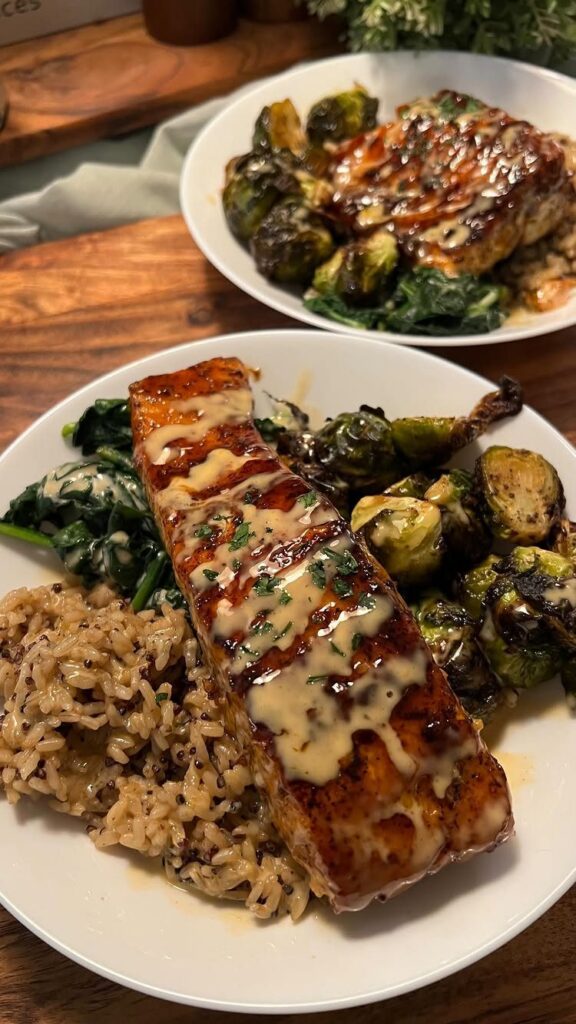 Glazed salmon fillets served with brown rice, roasted brussels sprouts, and sautéed spinach.